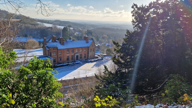 Sunlight flares into a prism from the top of Mariners Hill overlooking the house and estate at Chartwell in the snow.